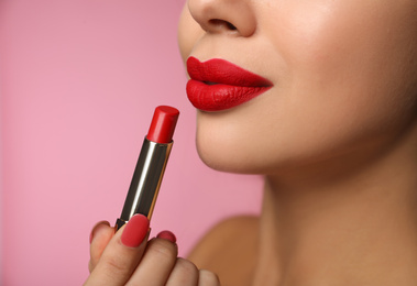 Photo of Woman with red lipstick on pink background, closeup