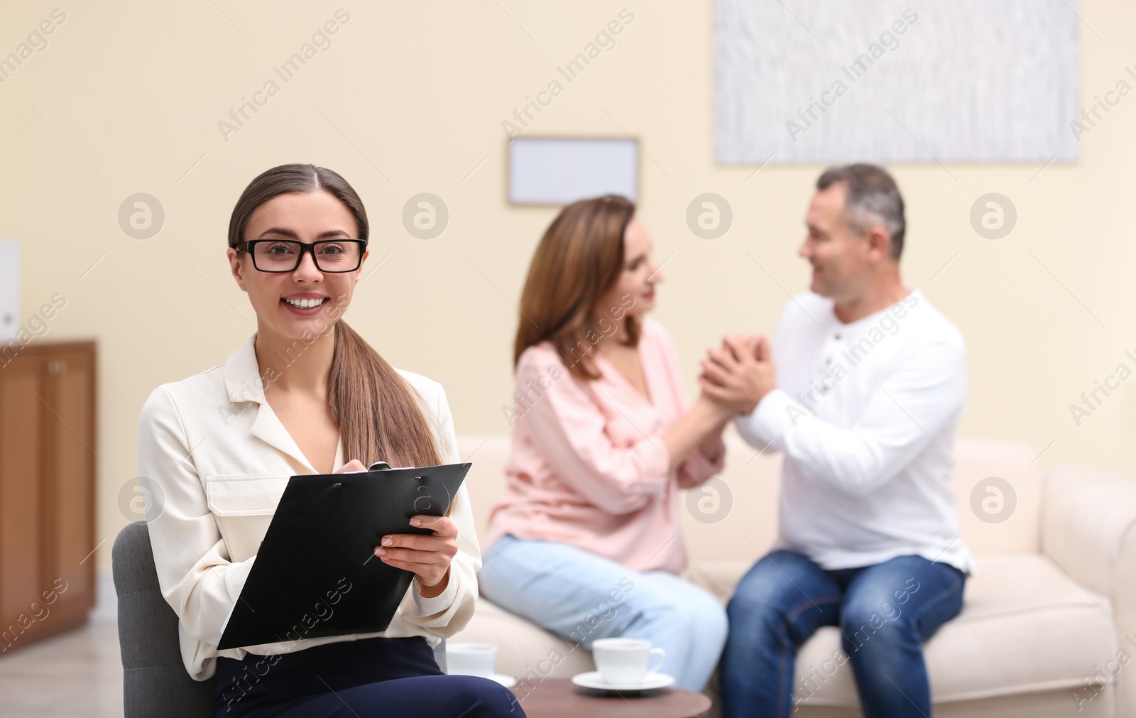 Photo of Psychotherapist and happy couple having meeting in office. Family counselling