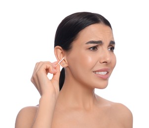 Young woman cleaning ear with cotton swab on white background