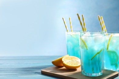 Photo of Delicious refreshing cocktail with ice on wooden table. Space for text