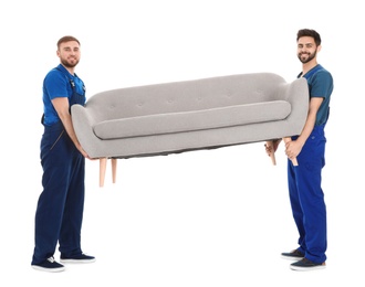 Photo of Young workers carrying sofa isolated on white. Moving service