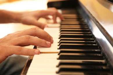 Photo of Man playing piano indoors, closeup. Music lesson