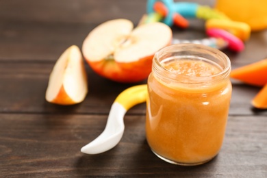 Jar with healthy baby food on table