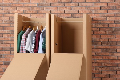 Photo of Wardrobe boxes with clothes against brick wall
