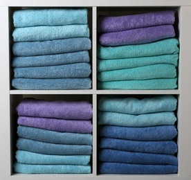 Photo of Colorful towels on shelves, closeup. Bathroom supplies