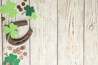 Flat lay composition with horseshoe on white wooden background, space for text. St. Patrick's Day celebration