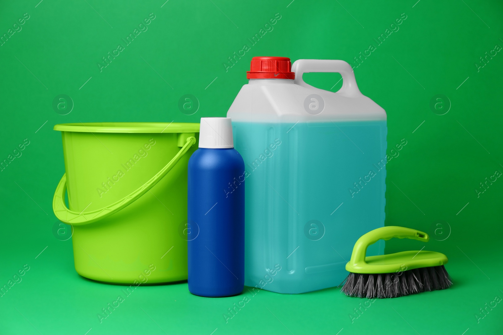 Photo of Bucket, cleaning supplies and tools on green background