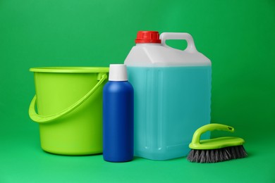 Photo of Bucket, cleaning supplies and tools on green background