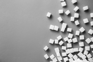 Refined sugar cubes on grey background, top view