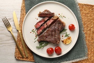 Photo of Delicious grilled beef steak served on light wooden table, top view