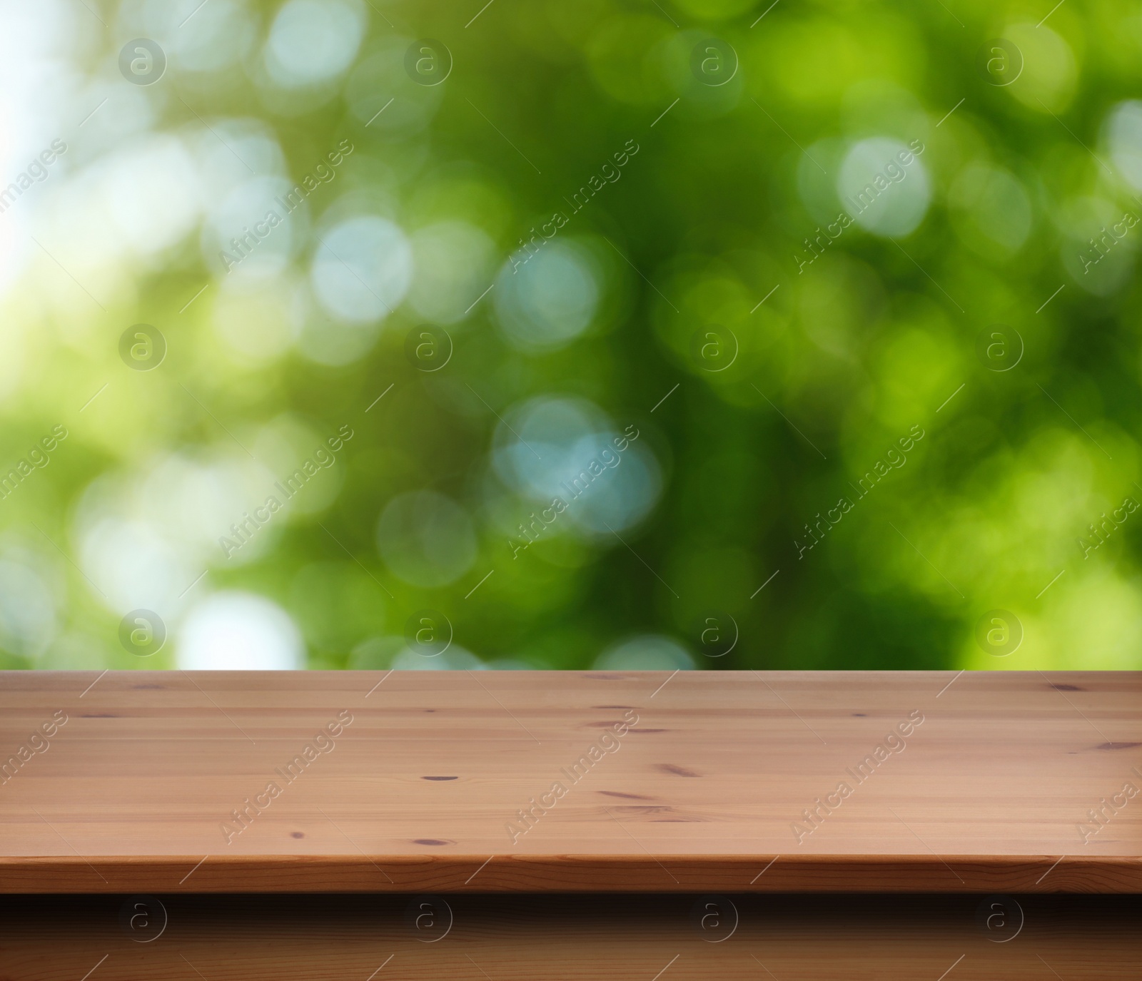 Image of Empty wooden surface against blurred green background. Space for design