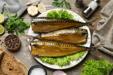 Flat lay composition with tasty smoked fish on wooden table