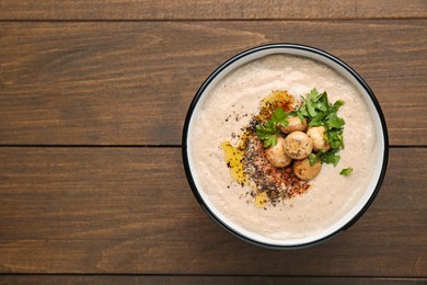 Delicious cream soup with mushrooms on wooden table, top view. Space for text