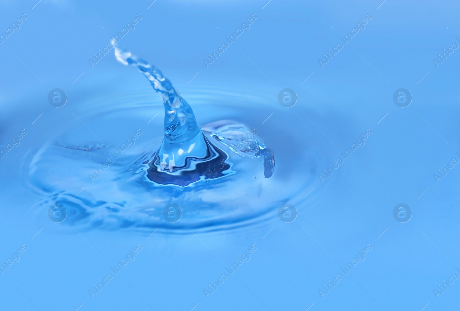 Photo of Splash of blue water as background, closeup. Space for text