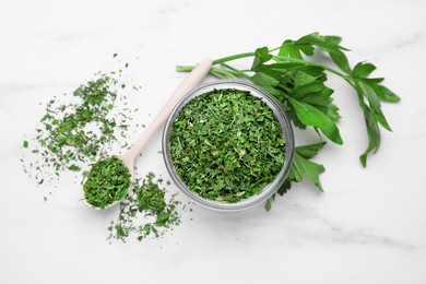 Photo of Dried aromatic parsley and fresh leaves on white marble table, flat lay