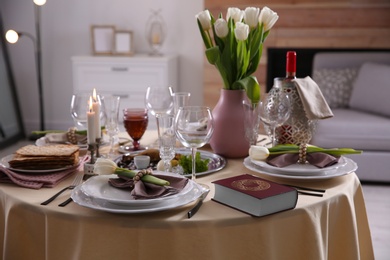 Festive Passover table setting with Torah at home. Pesach celebration