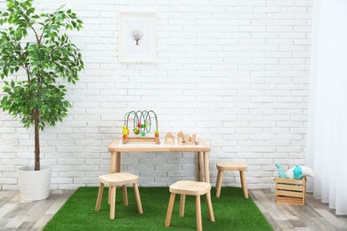 Photo of Stylish playroom interior with toys and modern wooden furniture