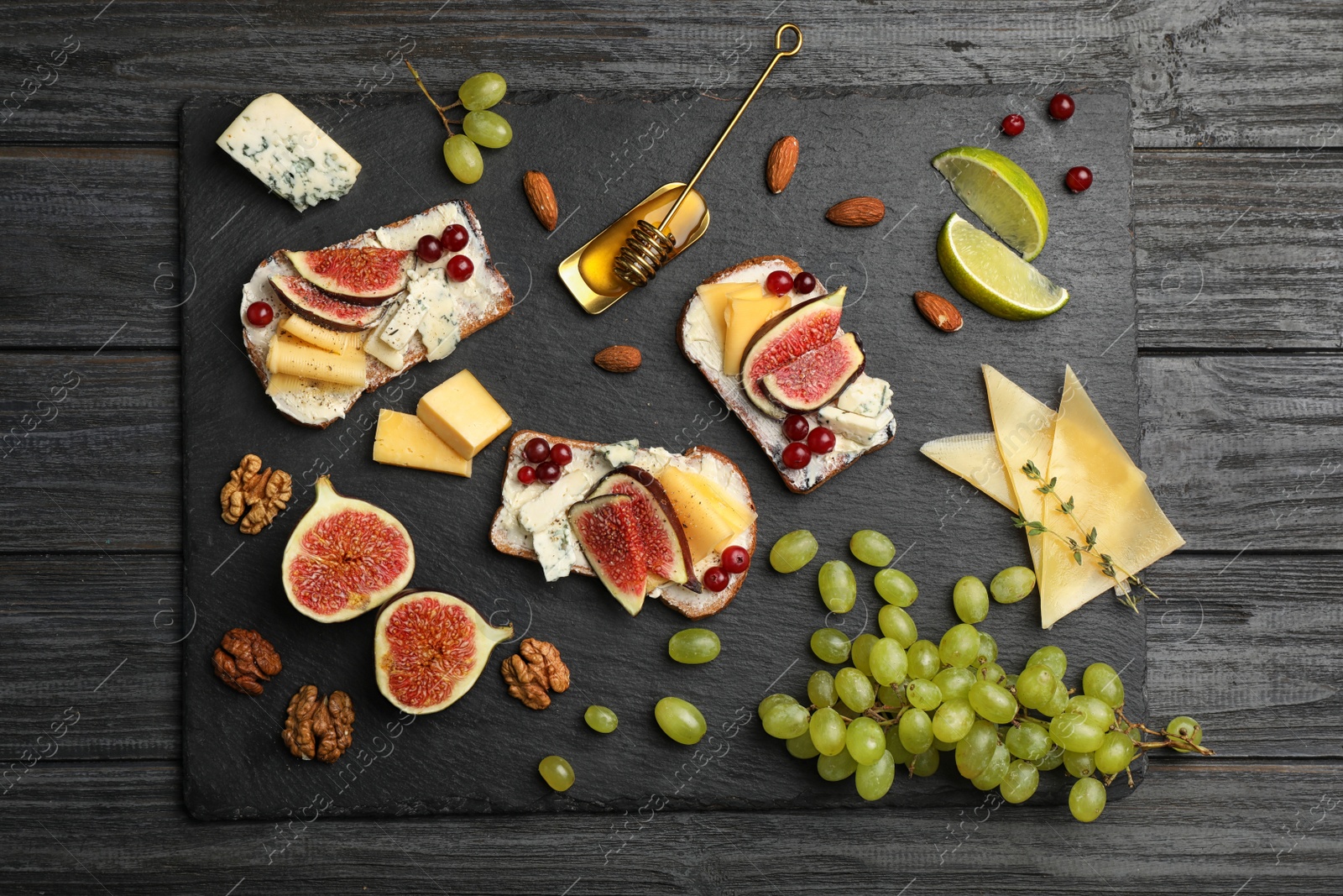 Photo of Sandwiches with ripe figs and delicious products on wooden background, top view