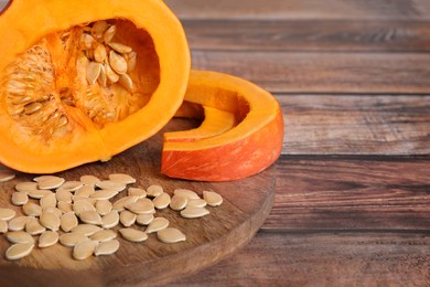 Fresh pumpkin and vegetable seeds on wooden table, closeup. Space for text