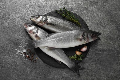 Tasty sea bass fish on grey textured table, flat lay