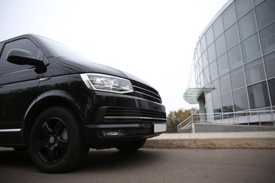 Photo of Black delivery van parked on street near building