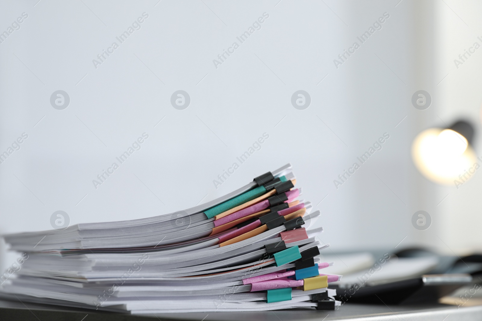 Photo of Stack of documents with paper clips on office table. Space for text