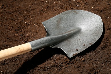 Photo of Metal shovel on fertile soil. Gardening tool