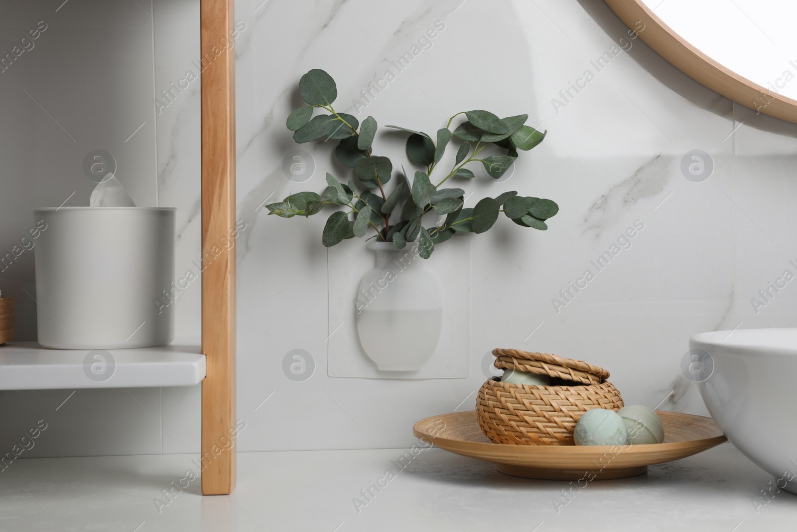 Photo of Silicone vase with eucalyptus branches on white marble wall over countertop in stylish bathroom