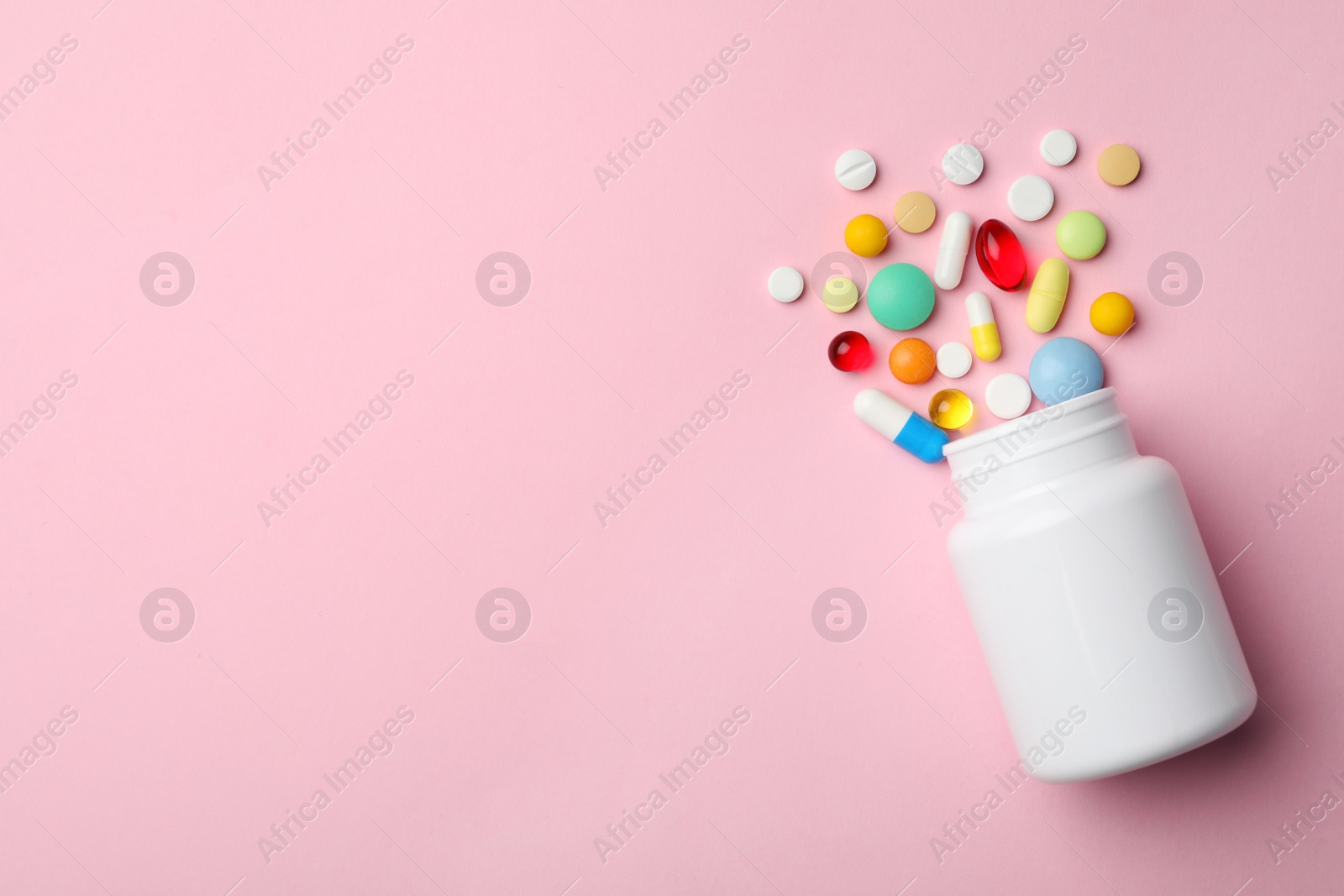 Photo of Bottle with different pills on color background, flat lay. Space for text