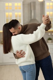 Photo of Affectionate young couple dancing in light kitchen