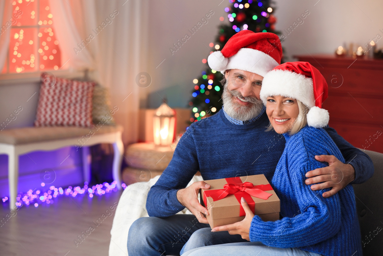 Photo of Happy couple opening Christmas gift at home