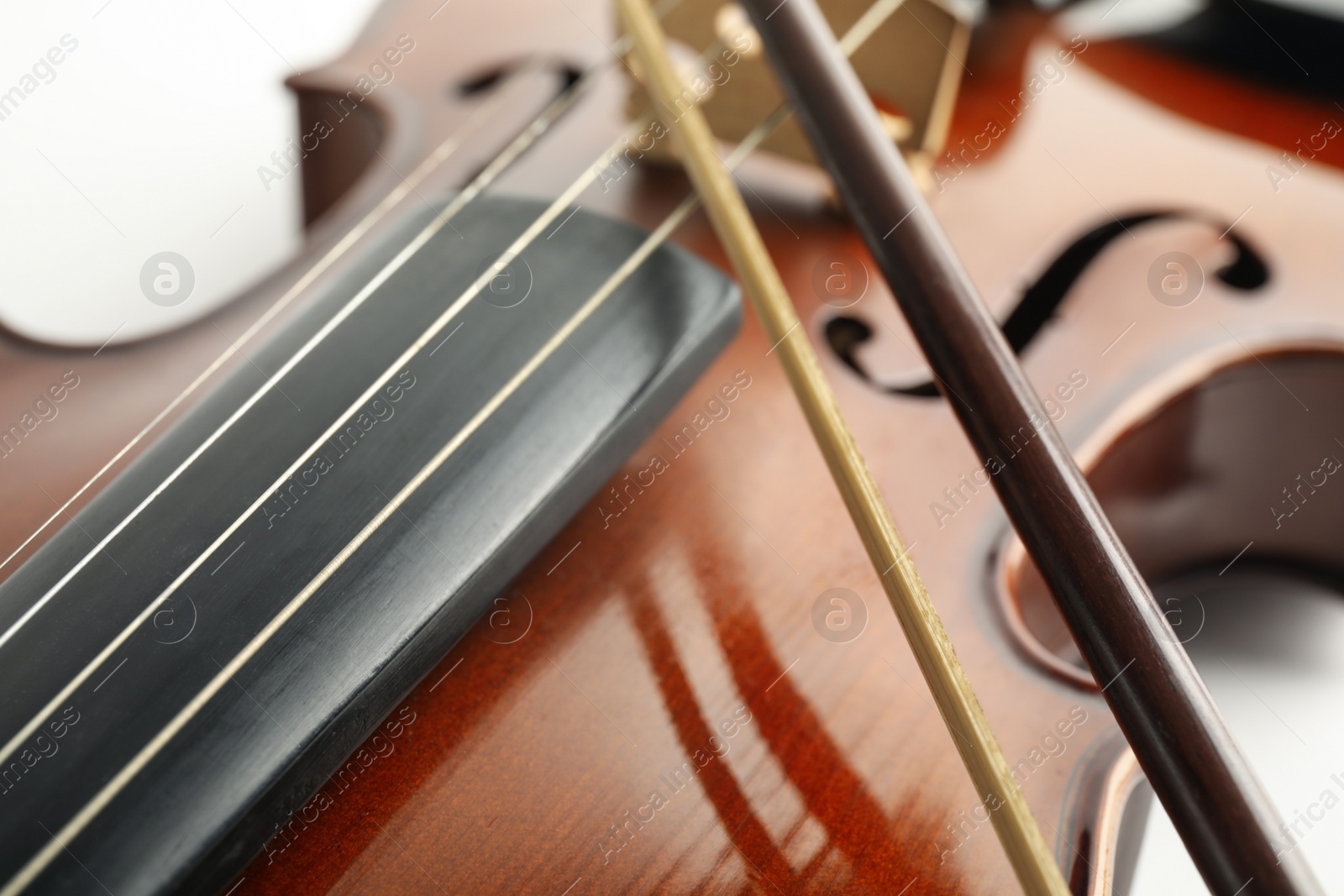 Photo of Beautiful classic violin and bow, closeup view. Musical instrument