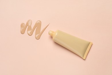 Photo of Liquid foundation and swatch on beige background, top view