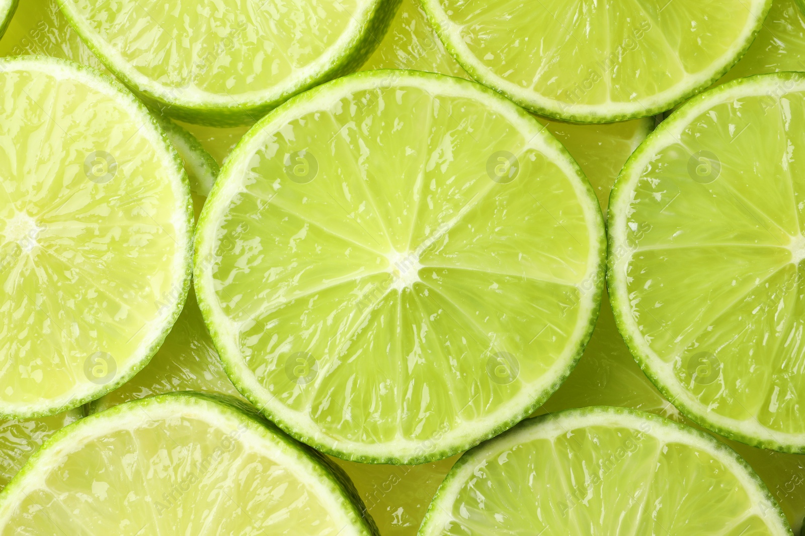 Photo of Fresh juicy lime slices as background, top view