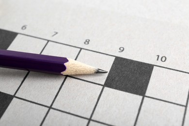 Photo of Pencil on blank crossword, closeup view. Space for text