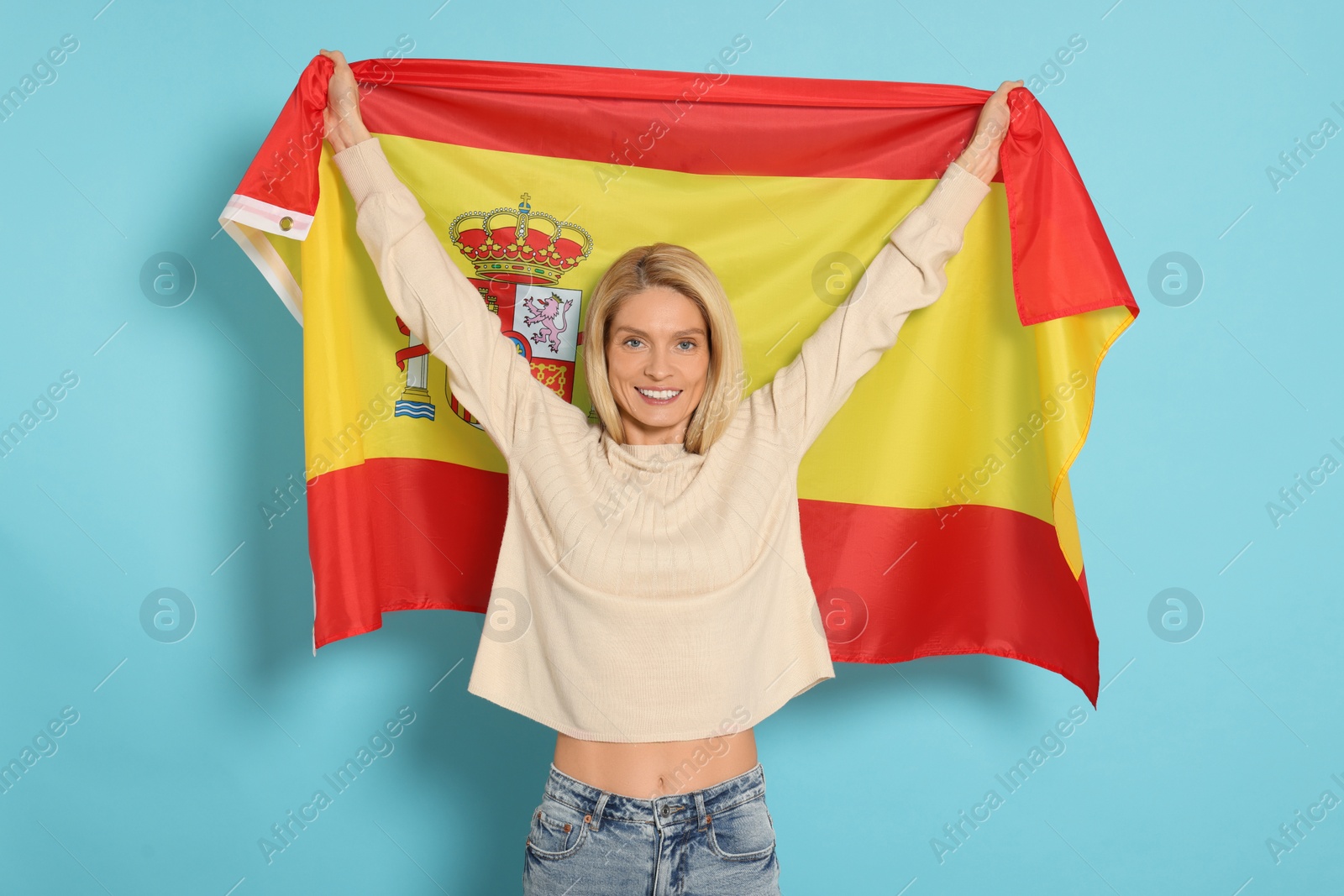 Photo of Woman with flag of Spain on light blue background