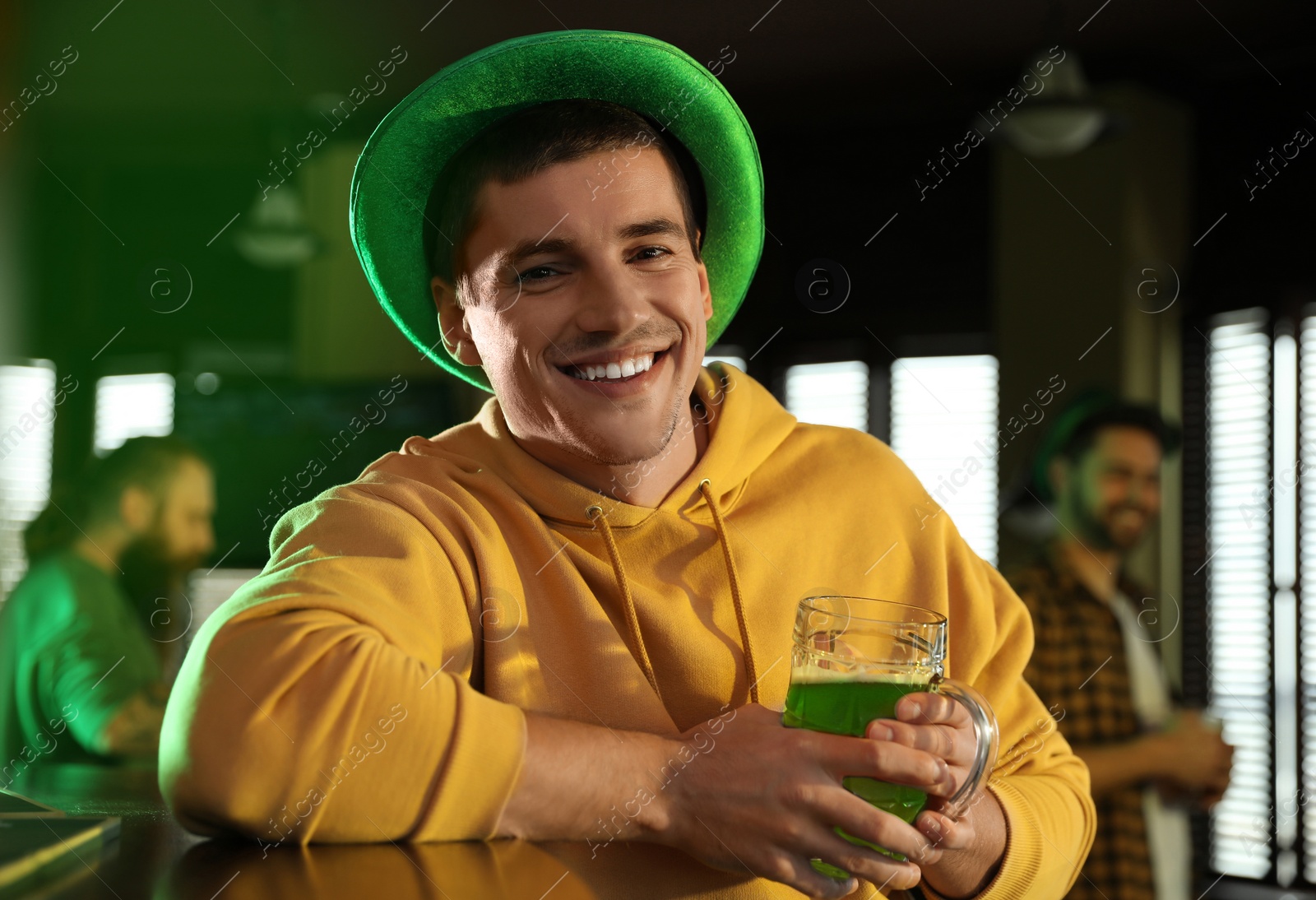 Photo of Man with glass of green beer in pub. St. Patrick's Day celebration