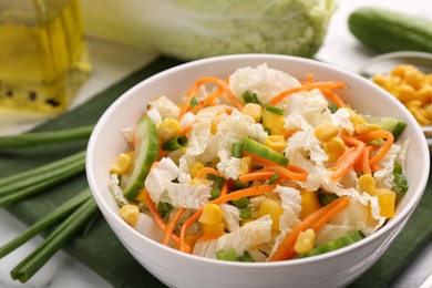 Tasty salad with Chinese cabbage, carrot, corn and cucumber in bowl on table, closeup