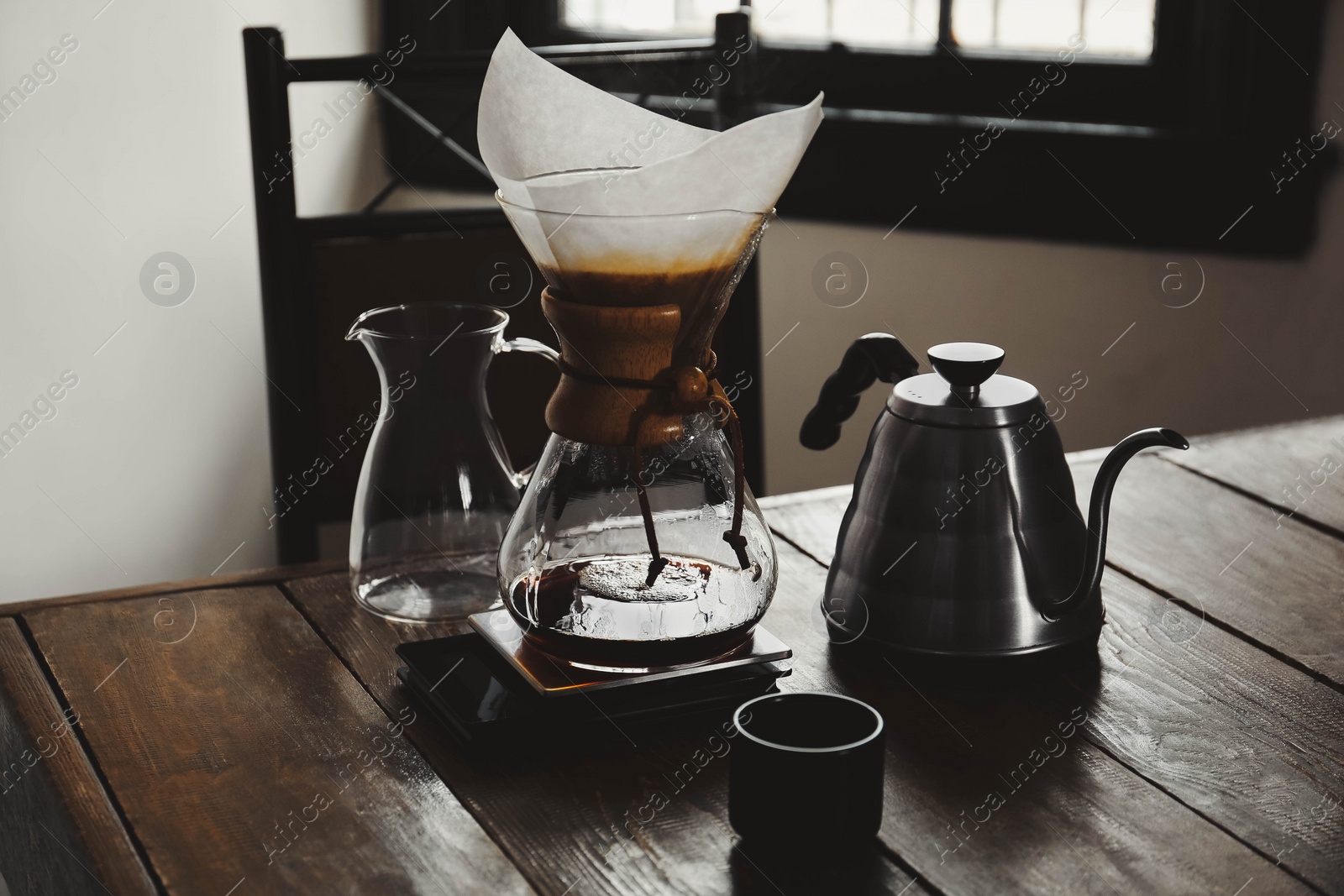 Photo of Dishware for coffee making on wooden table in cafe