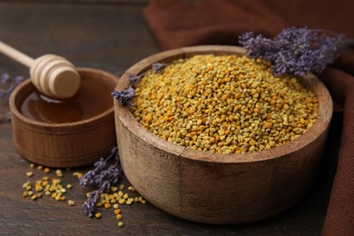 Fresh bee pollen granules, lavender, honey and dipper on wooden table, closeup