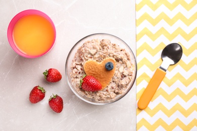 Photo of Tasty porridge served with berries and juice on marble table, flat lay. Creative idea for kids breakfast