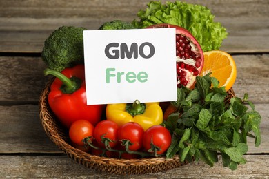 Photo of Tasty fresh GMO free products and paper card on wooden table