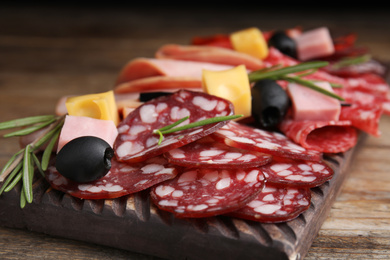 Tasty ham with other delicacies served on wooden table, closeup