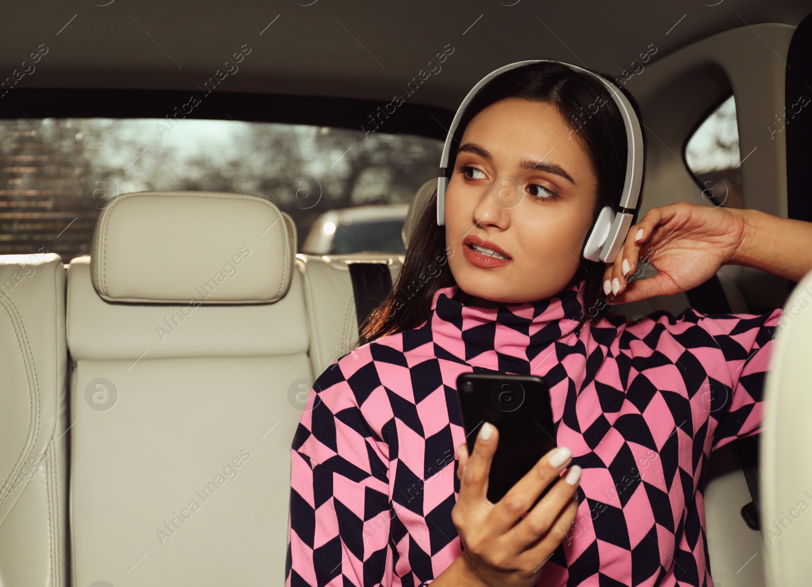 Photo of Young woman listening to audiobook in car