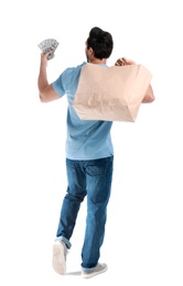 Photo of Young man with dollars and shopping bag on white background, back view