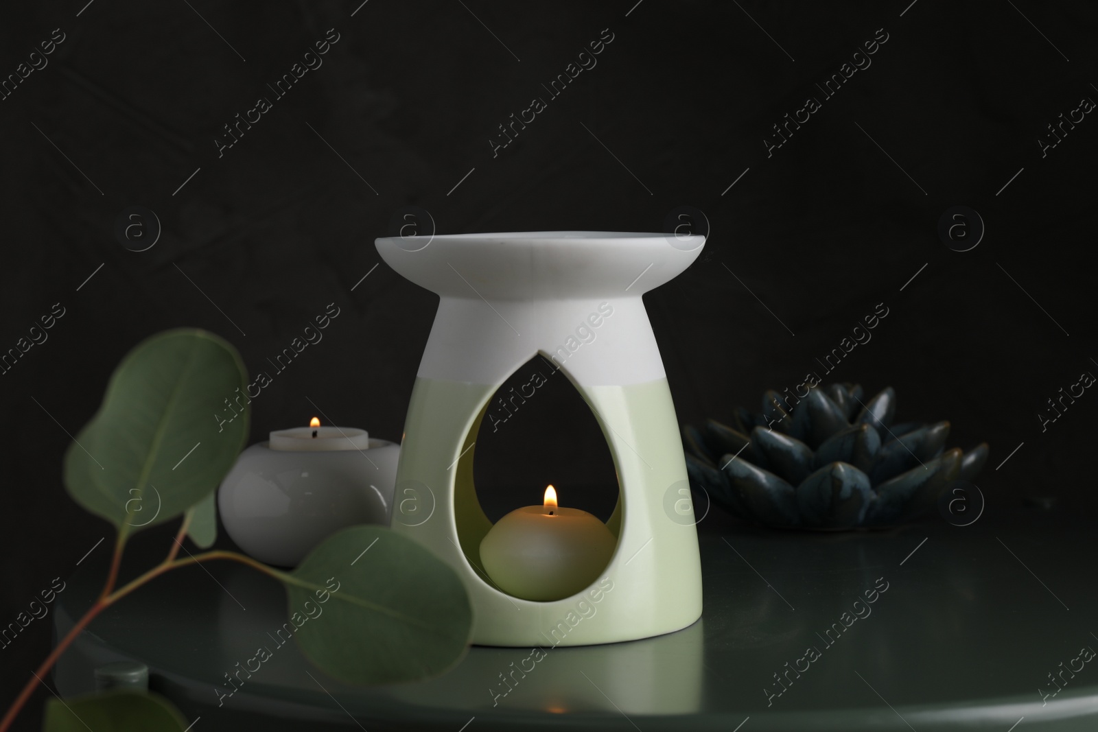 Photo of Aroma lamp with small candle on black table
