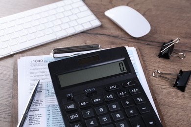 Photo of Tax accounting. Calculator, document, stationery, keyboard and computer mouse on wooden table, closeup