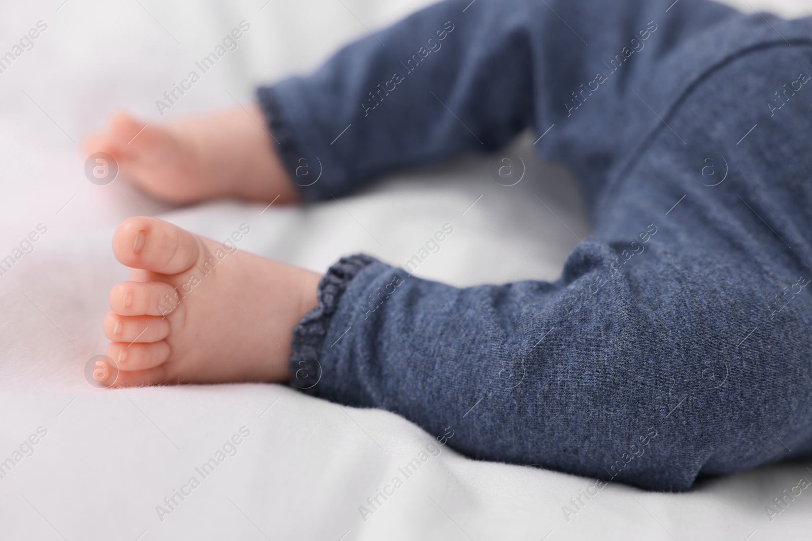 Photo of Newborn baby lying on white blanket, closeup