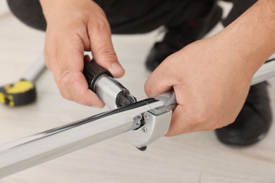 Worker installing new metal pipes indoors, closeup