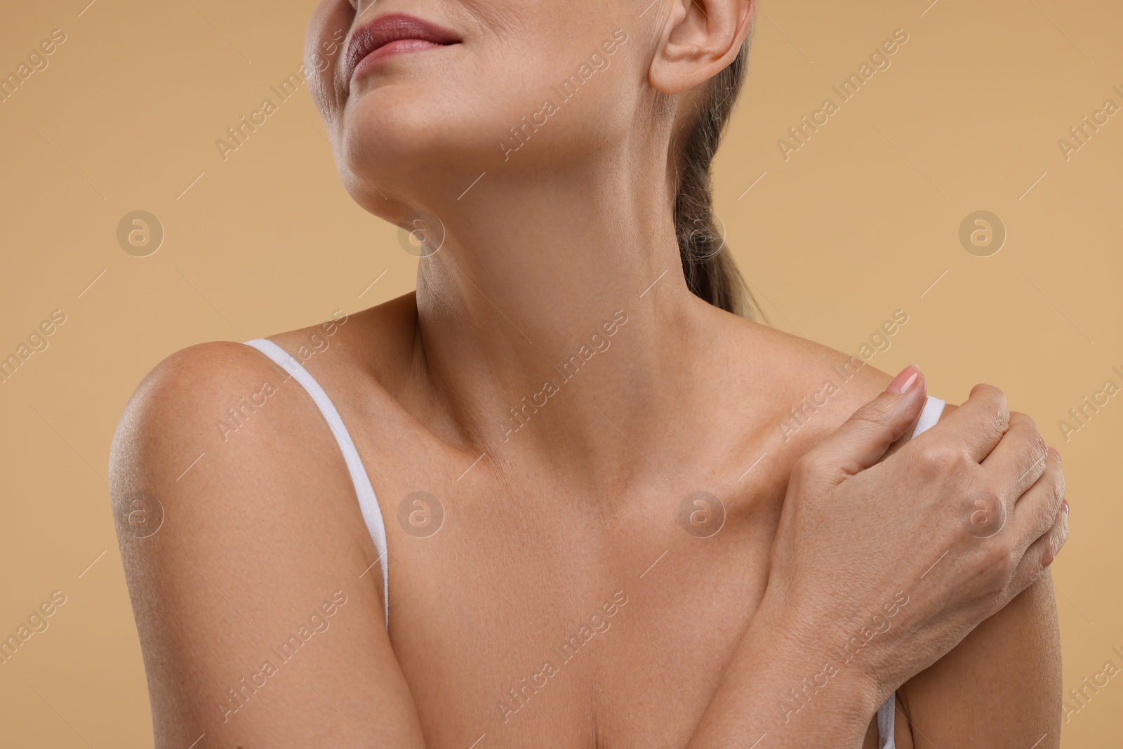 Photo of Mature woman with healthy skin on beige background, closeup